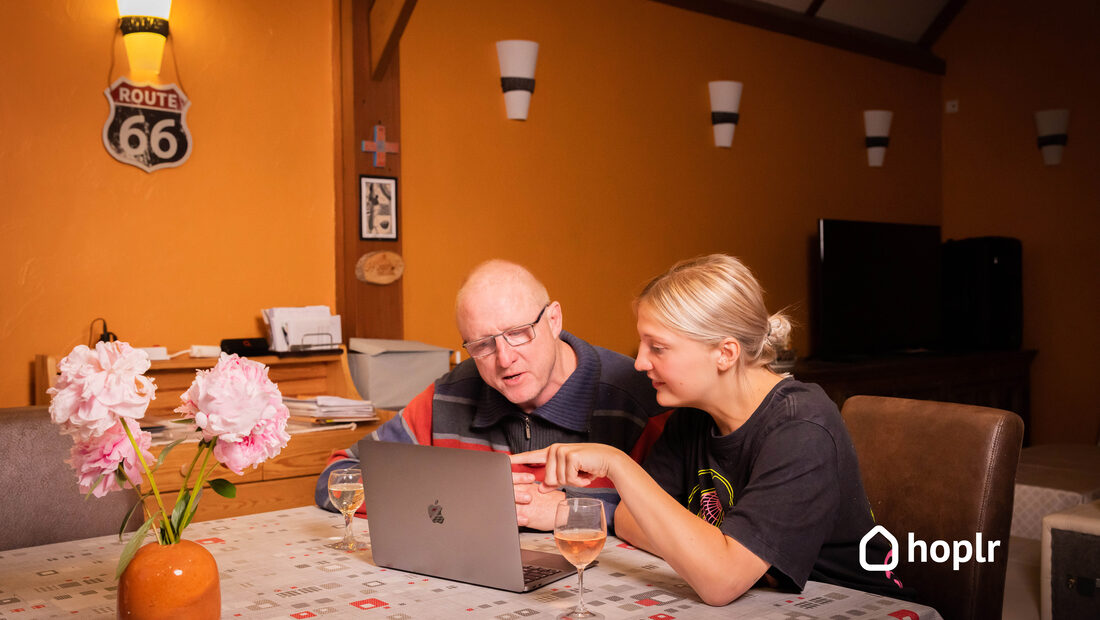 Twee buren zoeken samen iets uit op een laptop